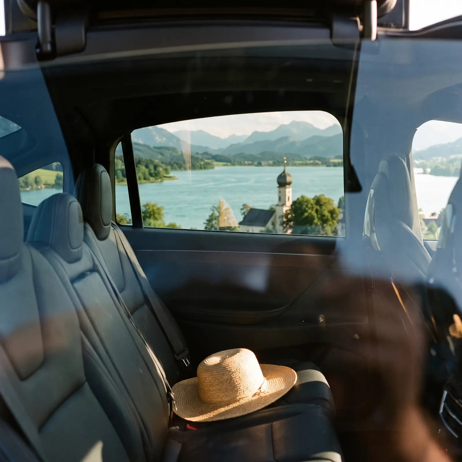 Blick aus dem Fond der MUC-Shuttle Limousine auf den Tegernsee mit Kirche und Bergen
